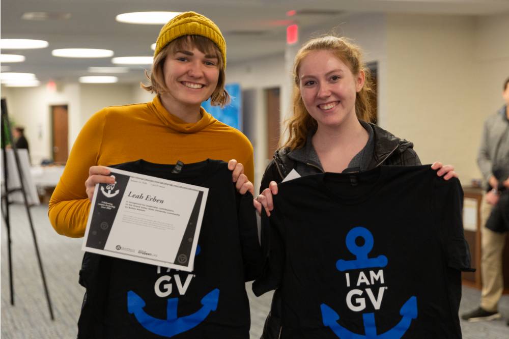 Two students showing their I am GV shirts.